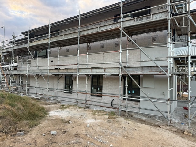 Scaffold platforms along a brick facade