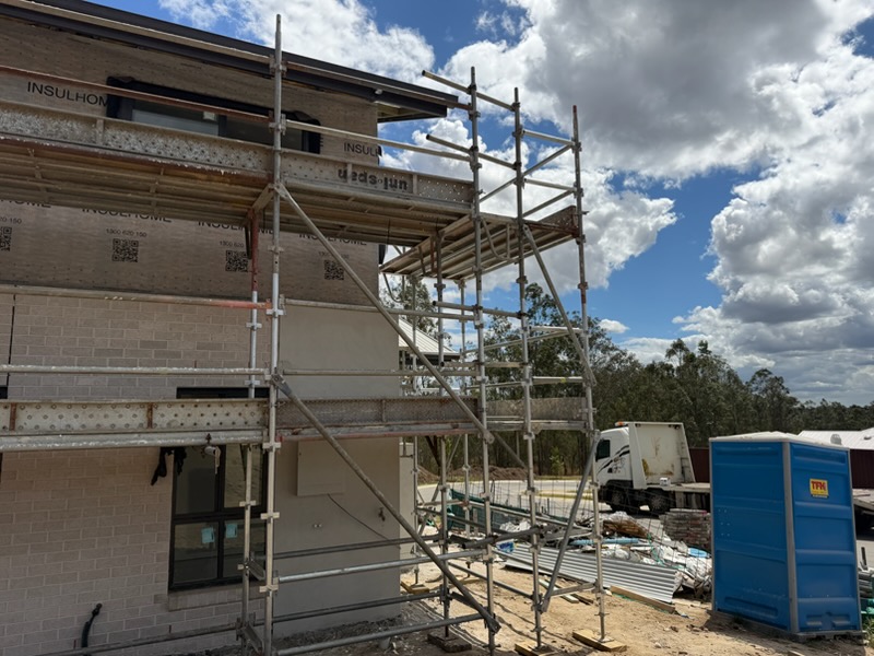 Two-level scaffold beside residential build